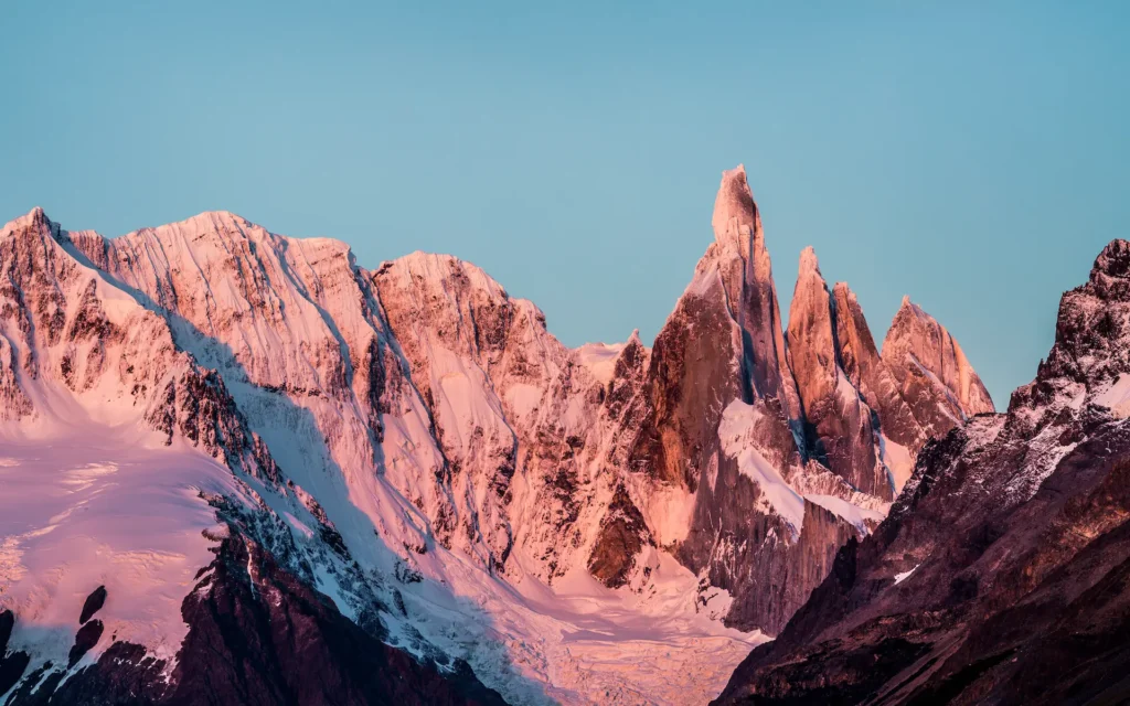 Dramatic sunset view of Cerro Torre and Mount Fitz Roy in Patagonia, Argentina—one of the safest and most breathtaking places to visit in South America for hiking and adventure.