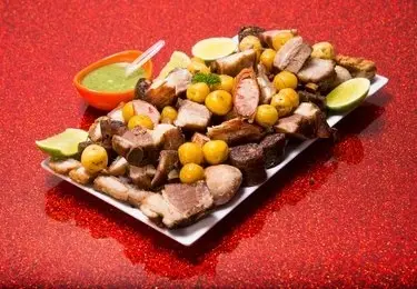 Traditional Colombian Fritanga platter with grilled and fried meats