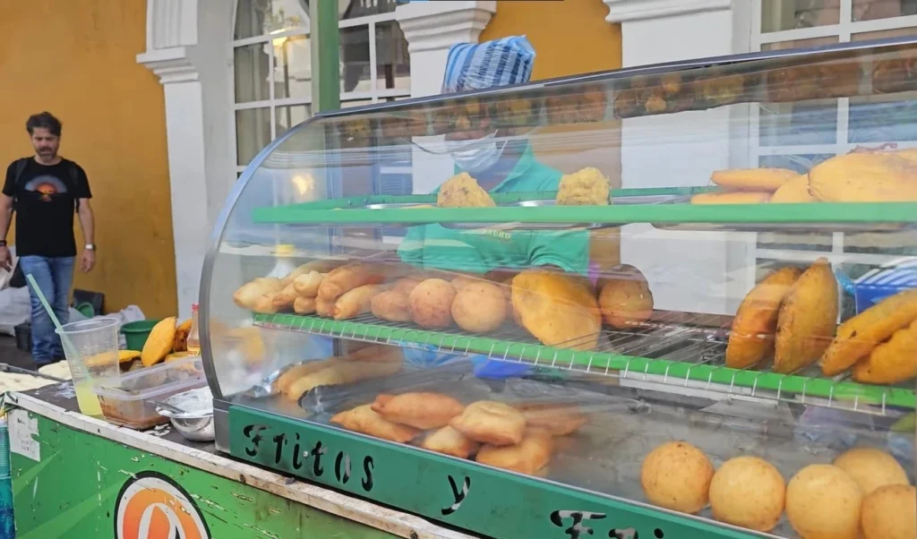 “Colombian street food vendor serving arepas, empanadas, and snacks